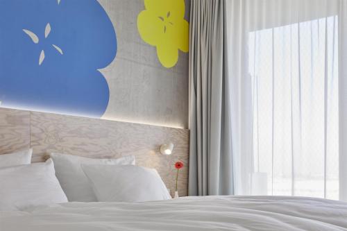 ein Schlafzimmer mit einem weißen Bett und einem Fenster in der Unterkunft Flowers Hotel Essen in Essen