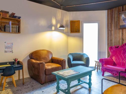 ein Wohnzimmer mit zwei Stühlen und einem Tisch in der Unterkunft Greet Hotel Limoges Nord in Limoges