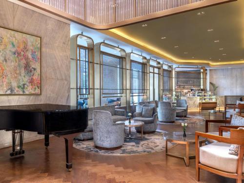 a living room with a piano and furniture at Sofitel Cairo Downtown Nile in Cairo