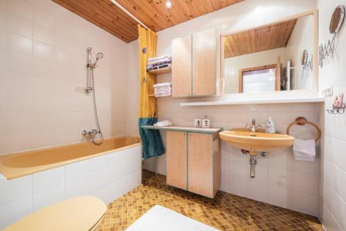 a bathroom with a sink and a tub and a toilet at Hotel Christina in Seefeld in Tirol