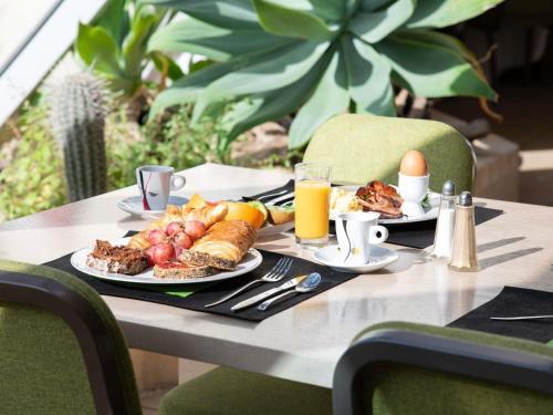 Una mesa con dos platos de desayuno encima. en Mercure Arles Centre Arenes, en Arles