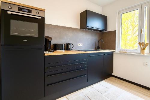 a kitchen with blue cabinets and a black appliance at Zentrumsnahe Wohnung mit Blick auf Siegens Obere Schloss in Siegen