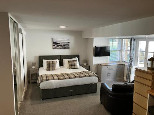 a bedroom with a bed and a television in it at The Penthouse Self Catering in Nairn