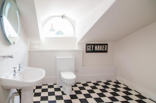 a bathroom with a sink and a toilet and a window at The Penthouse Self Catering in Nairn