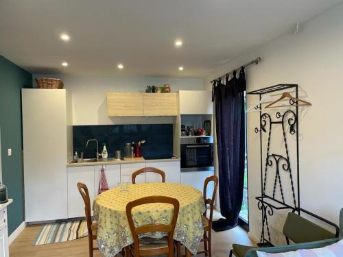a kitchen with a table and chairs in a room at logement au calme 