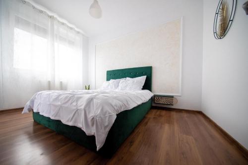 a bedroom with a large bed with a green headboard at Penthouse View in Arad