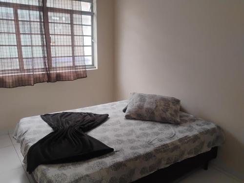 a bed with two pillows on it in a bedroom at Apartamento com 3 quartos a só 200 metros da Basílica in Aparecida