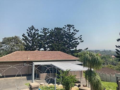a house with a roof with trees in the background at The Deyzel House in Durban