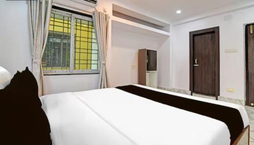 Un dormitorio con una cama blanca y una ventana. en Hotel AI Near Shalimar railway station, en Howrah