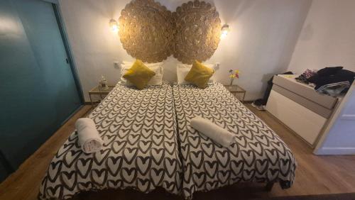 a bedroom with a black and white bed with yellow pillows at Vivienda Vacacional Casa Paulina in Punta del Hidalgo