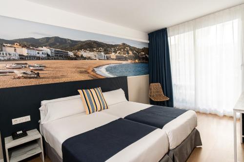 1 dormitorio con 1 cama y 1 playa en Hotel Don Juan Tossa, en Tossa de Mar