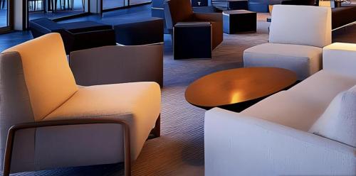 a lobby with white chairs and a table and tables at Best Western Plus Rialto in Rialto