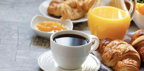 a cup of coffee and a plate of pastries and orange juice at Best Western Plus Rialto in Rialto
