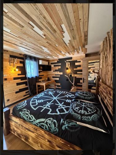 Un dormitorio con una cama en una habitación con paredes de madera. en Le VALHALLA chambre freya, en Forges-les-Eaux