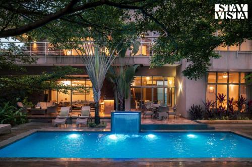 a swimming pool in front of a building at StayVista at Belmonte with Bonfire, Jacuzzi in Karjat