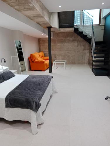 a bedroom with a bed and an orange couch at Aptos Living Libreros climatizados in Salamanca