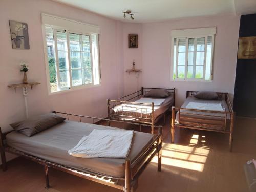 una camera con tre letti e due finestre di Albergue o Apalpador a Melide