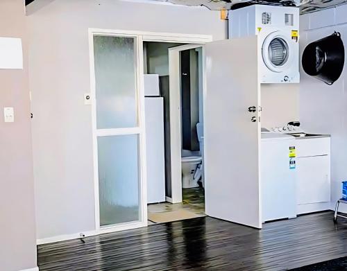 a room with a door and a washer and dryer at Park View 'Home Away From Home' in Feilding