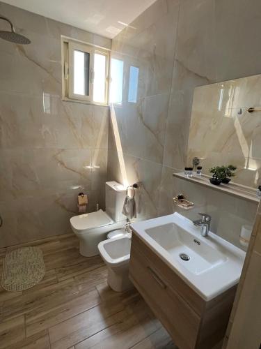 a bathroom with a toilet and a sink at Adriatic View Penthouse in Durrës