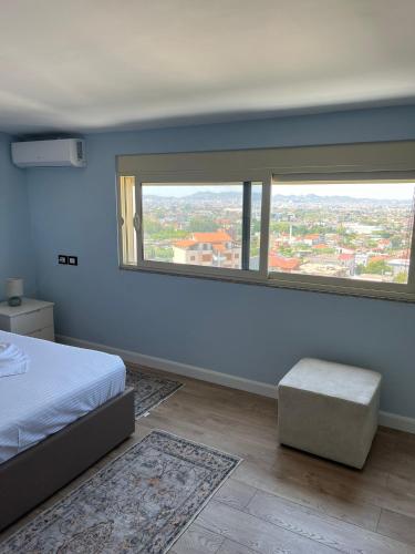 a bedroom with a bed and a large window at Adriatic View Penthouse in Durrës