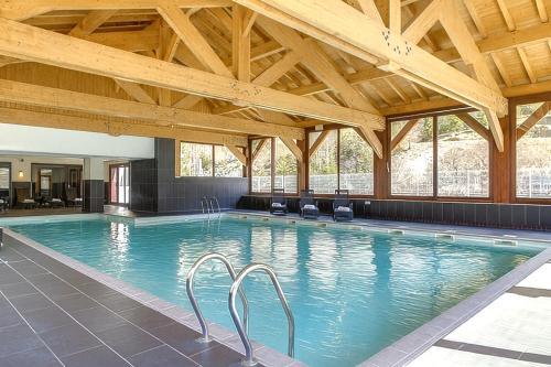 a large swimming pool with wooden ceilings and a large swimming pool at Chez Charles I Vallorcine Viachamonix in Vallorcine