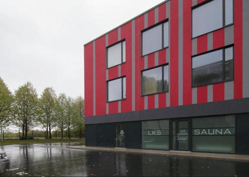 a red and black building in the rain at LKS apartments 2 in Kose