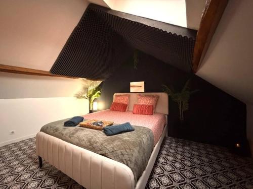 een slaapkamer met een groot bed met rode kussens bij Secret Room Elegance, mystère et intimité in Souppes-sur-Loing