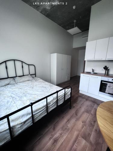a bedroom with a bed and white cabinets and a table at LKS apartments 2 in Koze