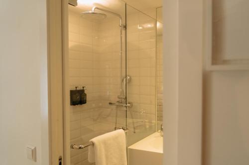 a bathroom with a shower and a tub and a sink at Max Brown Hotel Canal District, part of Sircle Collection in Amsterdam