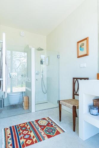 a white bathroom with a shower and a tub at Quinta Fonte Grande in Santiago do Cacém