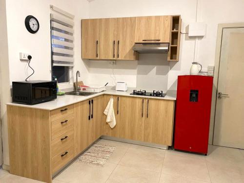 a kitchen with wooden cabinets and a red refrigerator at nulacaz in Rose Hill
