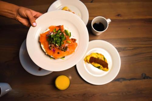 een persoon met een bord voedsel op een tafel bij Grand Dior in Tasjkent
