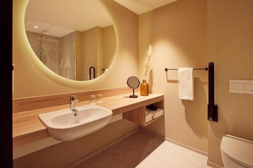 a bathroom with a sink and a mirror at Van der Valk Hotel Gent in Ghent
