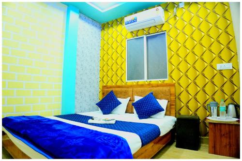 1 dormitorio con 1 cama con paredes azules y amarillas en Hotel Ganaraj Sharnam -Near Mahakaleshwar Jyotirlinga #Air Conditioning Room #Free WiFi #Parking - Room Service #Best Hotel In Ujjain, en Ujjain