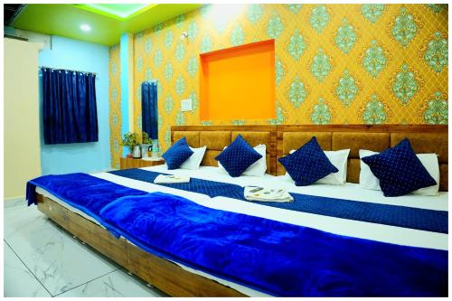 Un dormitorio con una cama grande con sábanas azules. en Hotel Ganaraj Sharnam -Near Mahakaleshwar Jyotirlinga #Air Conditioning Room #Free WiFi #Parking - Room Service #Best Hotel In Ujjain, en Ujjain