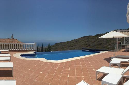 阿德耶Villa Sunset View Tenerife, Simply Amazing的带椅子和遮阳伞的游泳池