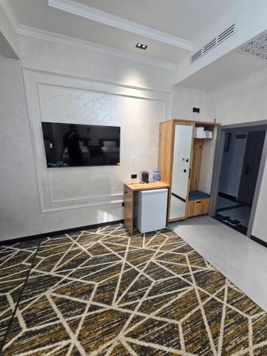 a room with a wall with a television and a table at Zamin Hotel in Zomin