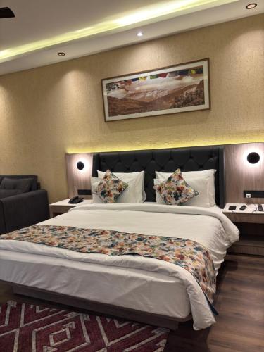 een hotelkamer met een groot bed met kussens bij Carom Hotel Manali in Manāli