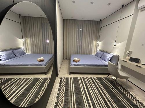 een slaapkamer met twee bedden en een spiegel bij ARĞYN Apartments, 3-BR Central in Astana