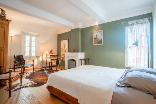 a bedroom with a bed and a fireplace and a table at Maison de charme à Lorgues in Lorgues