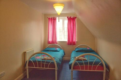 ステーンズにあるThe Penton Guest Houseの窓のある小さな部屋にベッドが2つある