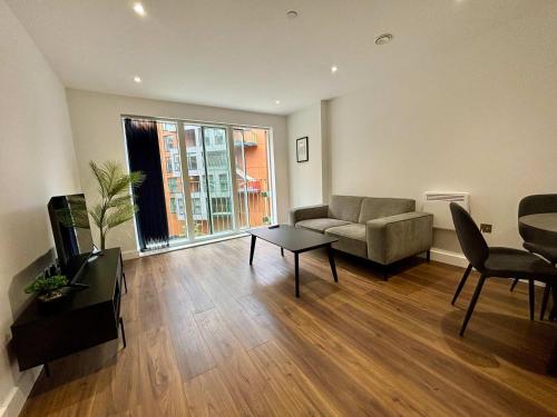 a living room with a couch and a table at 1 Bed Serviced Apartment Bracknell 5 mins from station in Bracknell