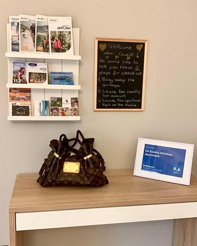a purse sitting on top of a table with a chalkboard at Da Sandro Holidays Apartment in Arco