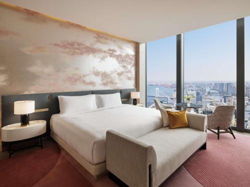 a bedroom with a large white bed and a couch at Fairmont Tokyo in Tokyo