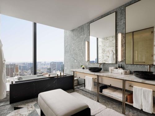 a bathroom with two sinks and a tub and a large window at Fairmont Tokyo in Tokyo