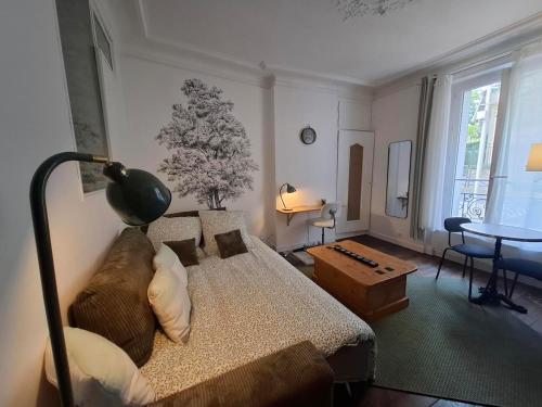 a living room with a bed and a table at Saint-Mandé studio, proche metro Ligne 1 & Paris Centre, Wifi rapide, Ideal couple, télétravail in Saint-Mandé