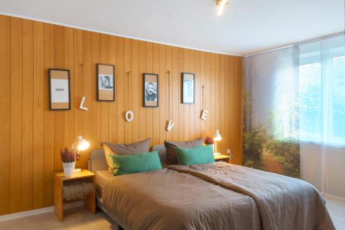 1 dormitorio con cama y pared con cuadros en Küstenglück, en Wilhelmshaven