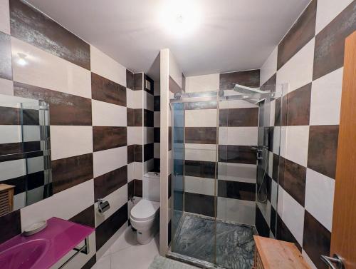 a bathroom with a toilet and a glass shower at Tabanka Azul - 2 BdR Cozy and Comfort Apt Near UN in Praia