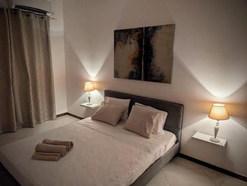 a bedroom with a bed with two lamps and two towels at Tabanka Azul - 2 BdR Cozy and Comfort Apt Near UN in Praia