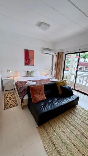 Un dormitorio con una cama y un sofá en una habitación. en Holiday House Kata & Karon Phuket Hotel, en Kata Beach